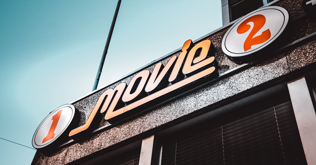 Low-angle shot of a vintage movie theater sign in Bern, Switzerland with a clear blue sky.